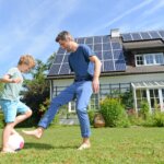 Dad Playing Football With Child In Garden