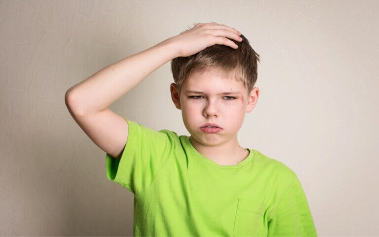 Is Heading The Ball In Football Bad For Your Child? Child Holding His Head In Pain