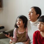 Child With Remote Sitting With Family
